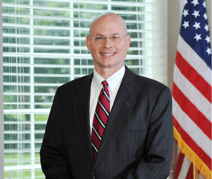 close up tom dunn in suit and tie smiling