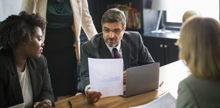 group of business people staring at a piece of paper