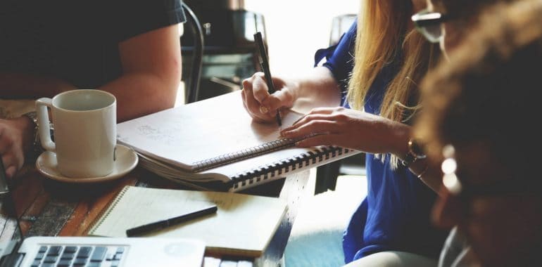 woman taking notes on a notebook in a business meeting