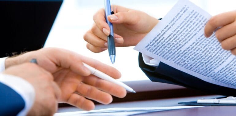 close-up of hands of people discussing documents