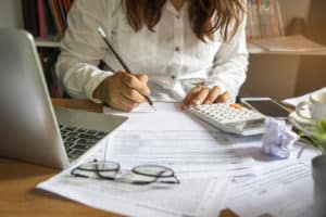 woman budget planning with computer and papers