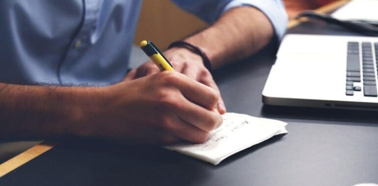 man writing on a notepad