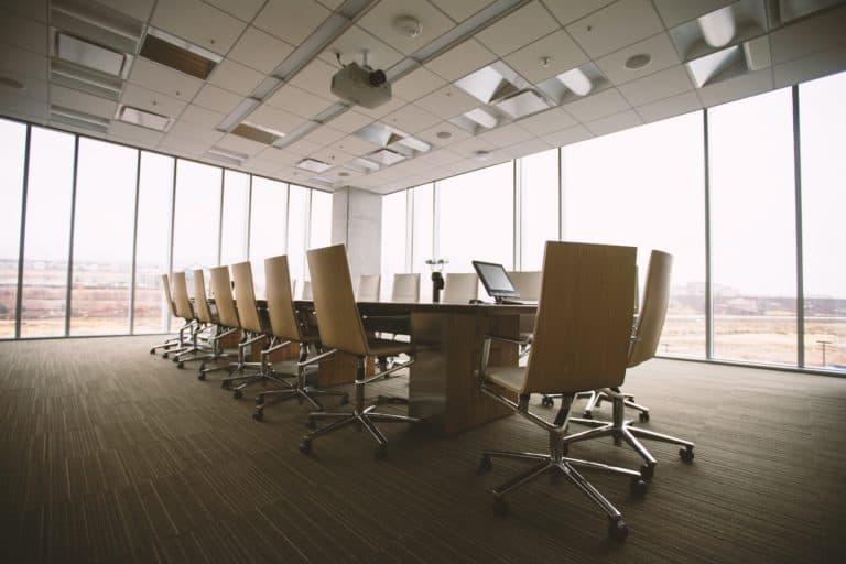 conference room with light wooden chairs in a room of windows