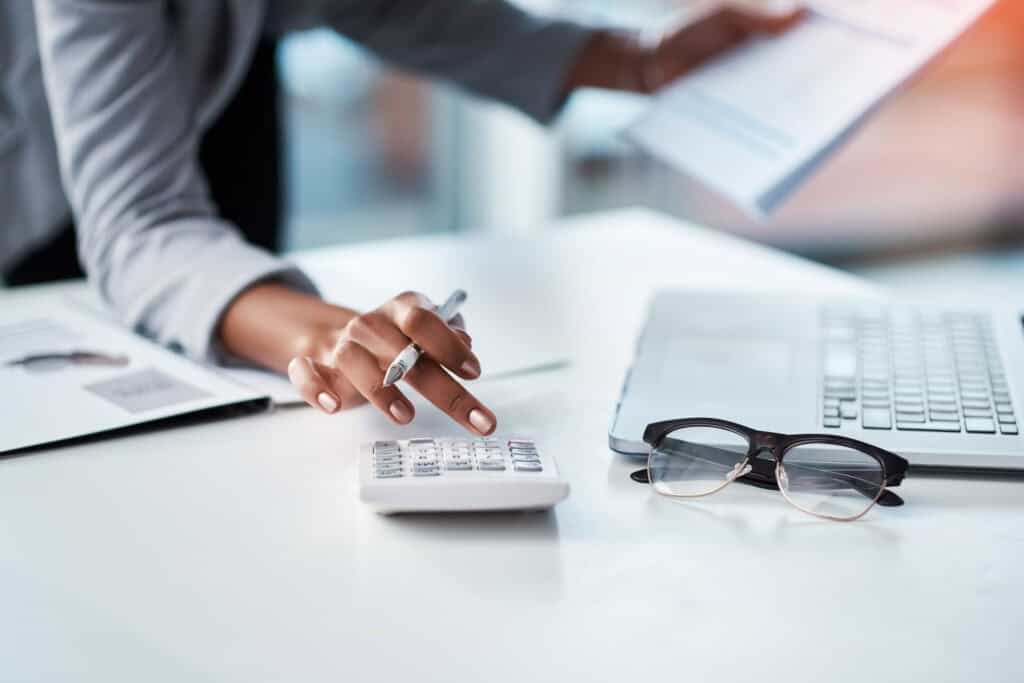 Person working with calculator and laptop
